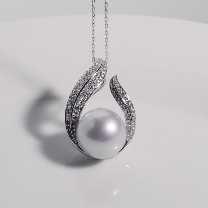 Lustrous white South Sea pearl with silver-blue and pink overtones in sculpted feather-inspired design