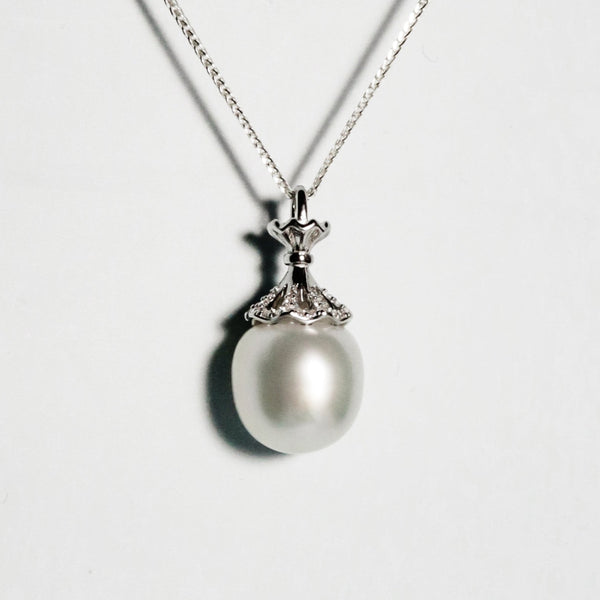 Lustrous near-round South Sea pearl with pink, and blue overtones in a delicate crown mount