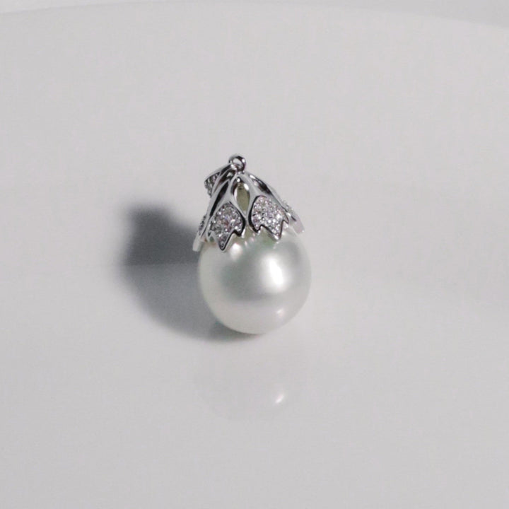Delicate leaf-like silver setting with cubic zirconia holding a luminous South Sea pearl