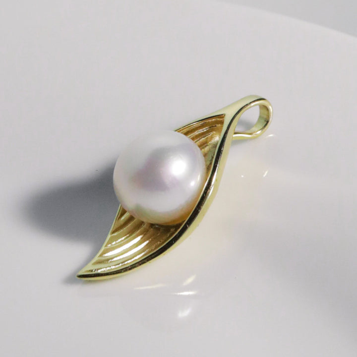 12.6mm white South Sea pearl with pink overtone cradled in a sculptural gold leaf setting