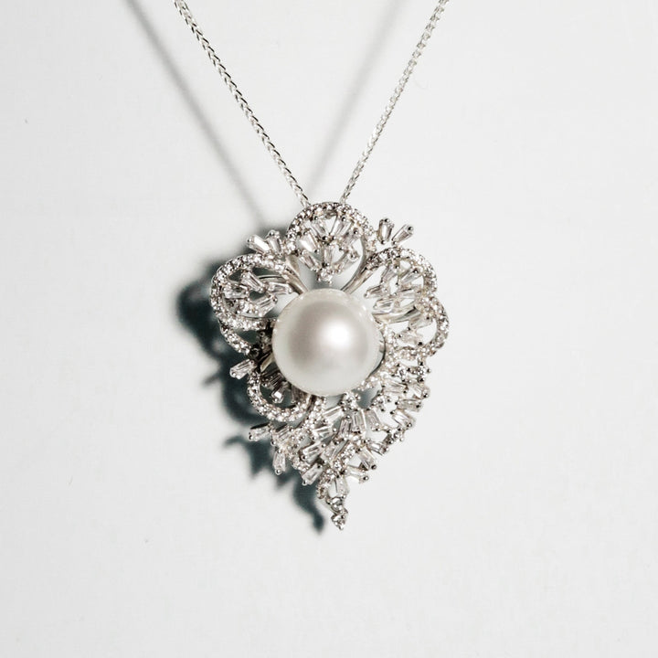 Round white South Sea pearl with soft pink overtone in a floral cubic zirconia setting